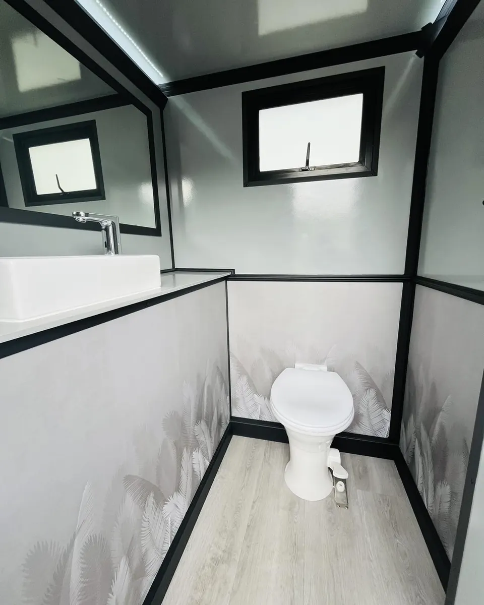 Toilet and window inside a restroom trailer