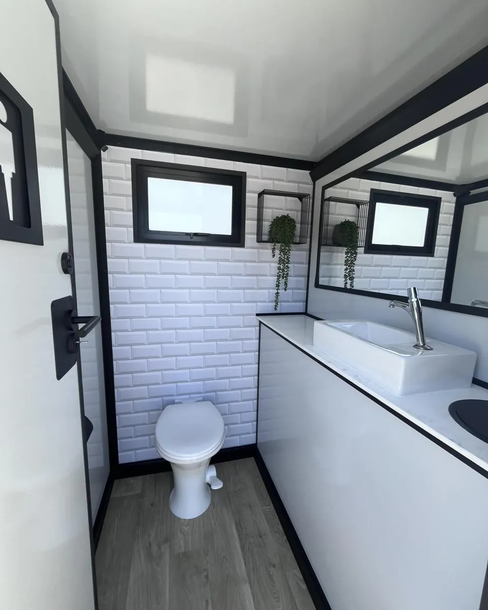 Restroom trailer interior with toilet and vanity